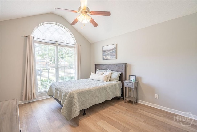 bedroom with lofted ceiling, light wood-type flooring, baseboards, and a ceiling fan
