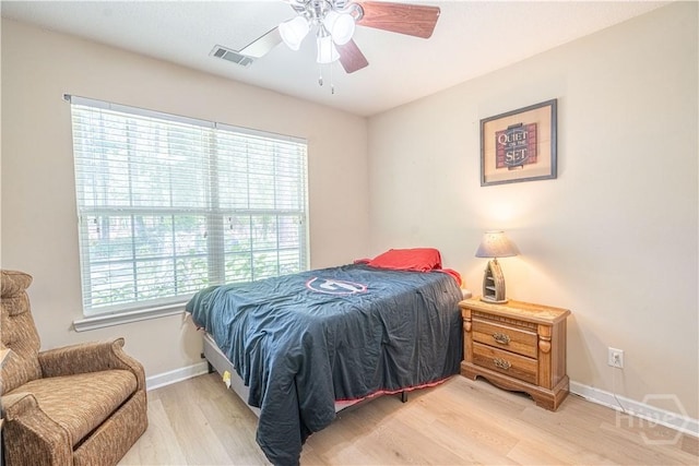 bedroom featuring light wood-style flooring, baseboards, and ceiling fan