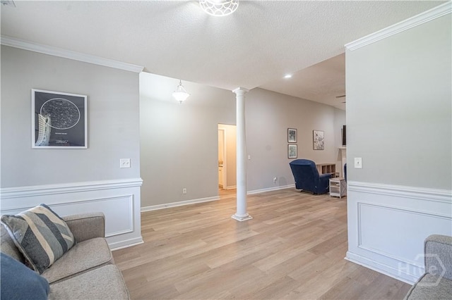 unfurnished living room with decorative columns, light wood-type flooring, crown molding, and recessed lighting