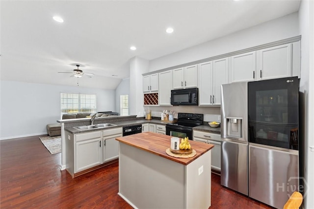 kitchen featuring black appliances, butcher block countertops, a peninsula, a sink, and open floor plan