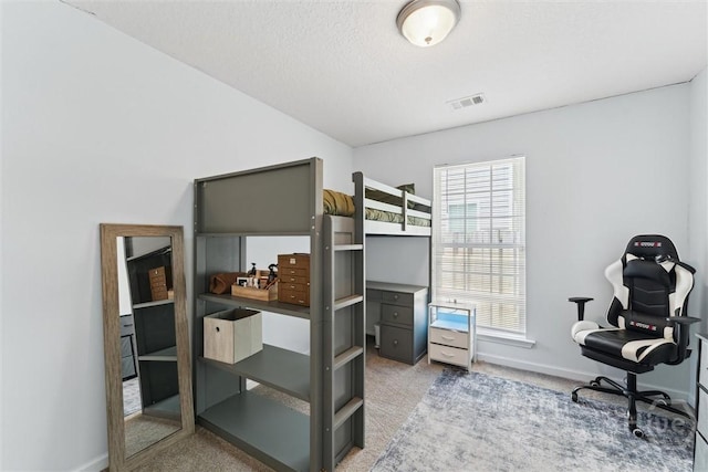 bedroom with light colored carpet, baseboards, and an office area