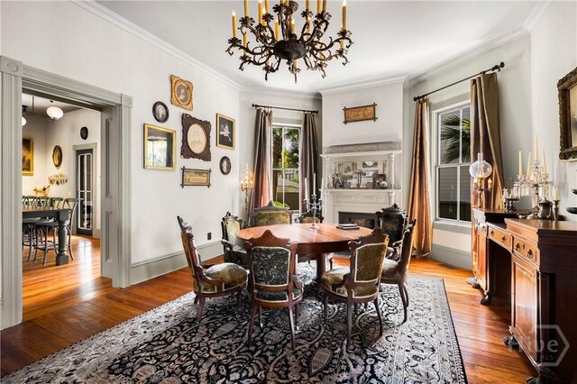 102 E 38th St, Savannah, GA 31401 - dining area featuring a chandelier, light wood finished floors, crown molding, a fireplace, and baseboards