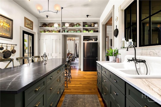 102 E 38th St, Savannah, GA 31401 - kitchen with freestanding refrigerator, dark wood finished floors, a sink, and a chandelier