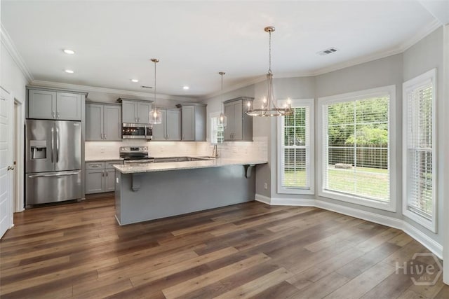 kitchen with stainless steel appliances, gray cabinets, a peninsula, crown molding, and decorative backsplash