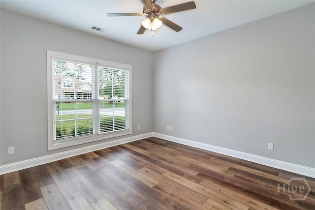 unfurnished room featuring baseboards, dark wood-type flooring, and a ceiling fan