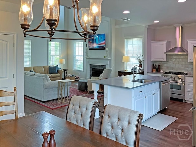 66 Misty Marsh Dr, Savannah, GA 31419 - kitchen with a chandelier, wall chimney range hood, appliances with stainless steel finishes, open floor plan, and crown molding
