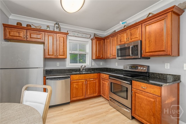 18 Silver Ave Unit 1, Tybee Island, GA 31328 - kitchen with appliances with stainless steel finishes, ornamental molding, light wood finished floors, and brown cabinetry