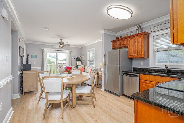 18 Silver Ave Unit 1, Tybee Island, GA 31328 - kitchen featuring appliances with stainless steel finishes, a sink, brown cabinetry, light wood-style flooring, and a ceiling fan
