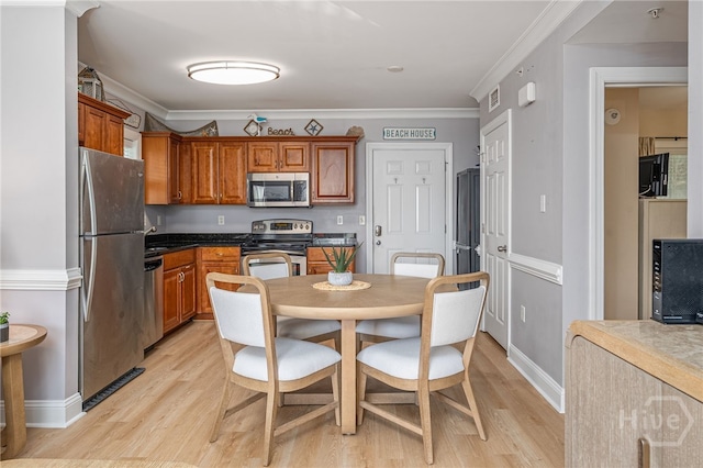18 Silver Ave Unit 1, Tybee Island, GA 31328 - kitchen with stainless steel appliances, light wood finished floors, brown cabinets, and ornamental molding