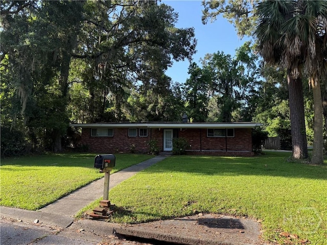 ranch-style home featuring a front yard and brick siding