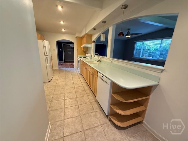 kitchen featuring white appliances, arched walkways, a sink, light countertops, and ceiling fan