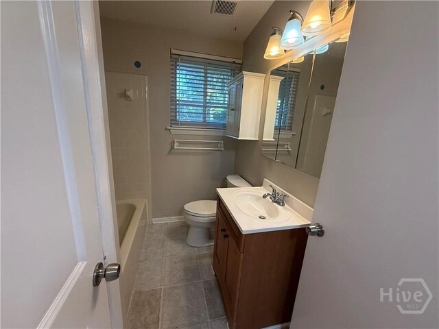 bathroom featuring tile patterned flooring, toilet, vanity, and baseboards