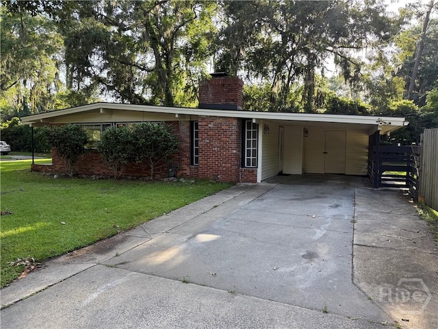 view of front facade with a chimney, driveway, brick siding, and an attached carport