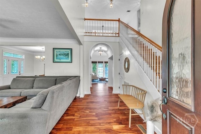 473 Kolic Helmey Rd, Guyton, GA 31312 - foyer entrance with arched walkways, stairs, crown molding, wood finished floors, and a chandelier