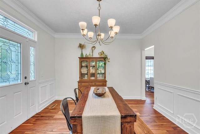 473 Kolic Helmey Rd, Guyton, GA 31312 - dining area with a chandelier, crown molding, wood finished floors, wainscoting, and a decorative wall