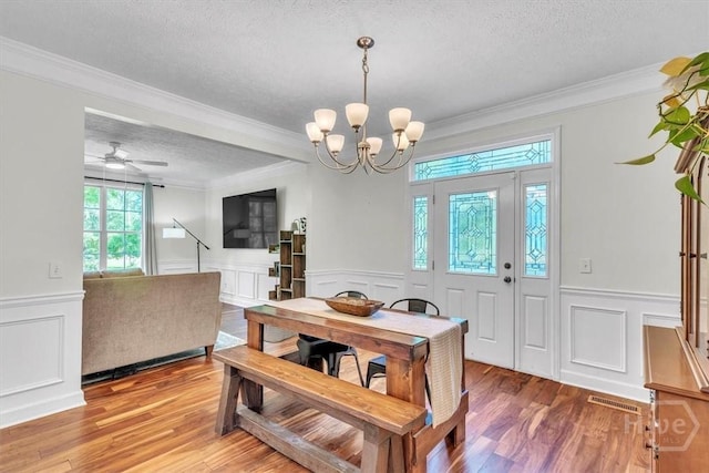 473 Kolic Helmey Rd, Guyton, GA 31312 - dining room featuring a textured ceiling, wainscoting, a decorative wall, a chandelier, and light wood-type flooring
