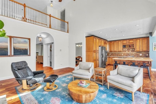 473 Kolic Helmey Rd, Guyton, GA 31312 - living area with arched walkways, light wood-style floors, baseboards, a high ceiling, and recessed lighting