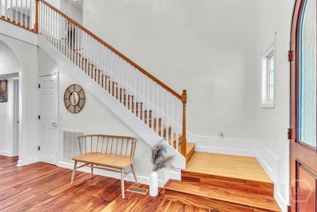 473 Kolic Helmey Rd, Guyton, GA 31312 - staircase featuring wood finished floors, arched walkways, baseboards, and a towering ceiling