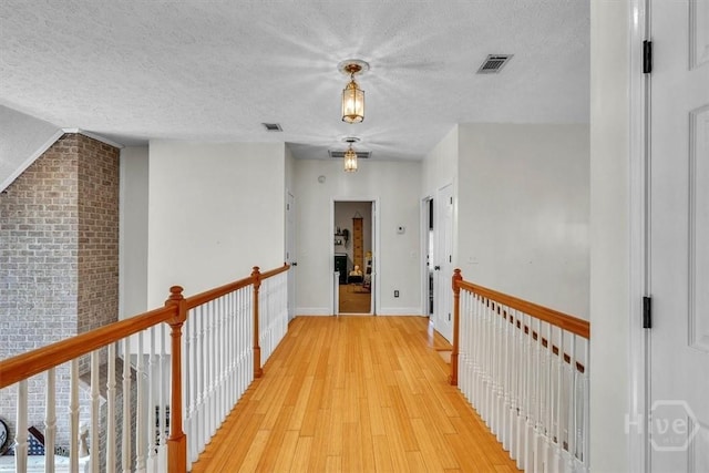 473 Kolic Helmey Rd, Guyton, GA 31312 - hall with light wood-type flooring, a textured ceiling, and baseboards