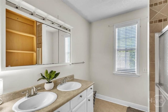 473 Kolic Helmey Rd, Guyton, GA 31312 - full bath featuring tile patterned floors, baseboards, double vanity, and a shower with door