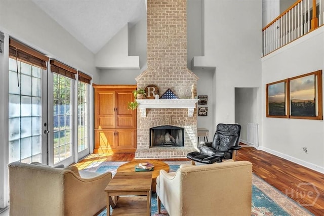 473 Kolic Helmey Rd, Guyton, GA 31312 - living room with high vaulted ceiling, baseboards, wood finished floors, a fireplace, and french doors