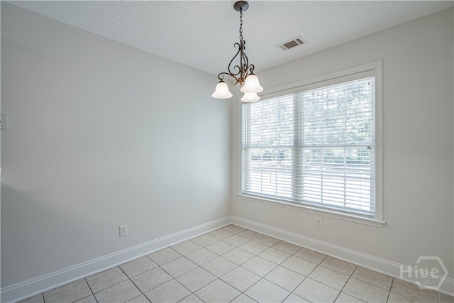 110 Pembroke Pl, Pembroke, GA 31321 - unfurnished room with a chandelier, plenty of natural light, baseboards, a textured ceiling, and light tile patterned floors