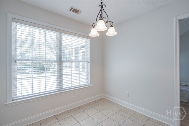 110 Pembroke Pl, Pembroke, GA 31321 - spare room featuring plenty of natural light, light tile patterned floors, baseboards, a chandelier, and a textured ceiling