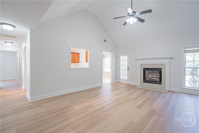 110 Pembroke Pl, Pembroke, GA 31321 - unfurnished living room with high vaulted ceiling, ceiling fan, light wood finished floors, a tiled fireplace, and baseboards