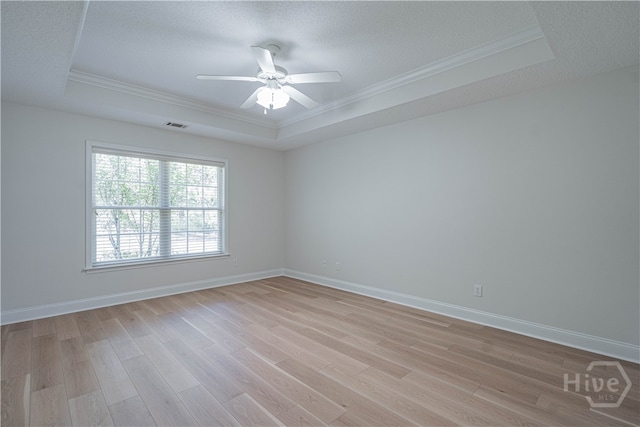 110 Pembroke Pl, Pembroke, GA 31321 - unfurnished room with a tray ceiling, ornamental molding, light wood-type flooring, a ceiling fan, and a textured ceiling