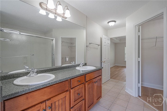 110 Pembroke Pl, Pembroke, GA 31321 - bathroom featuring a stall shower, a walk in closet, double vanity, tile patterned flooring, and baseboards
