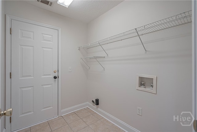 110 Pembroke Pl, Pembroke, GA 31321 - laundry room featuring hookup for a washing machine, baseboards, light tile patterned floors, and a textured ceiling