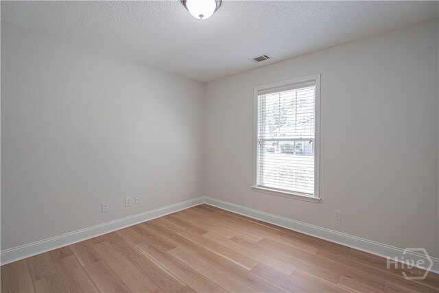 110 Pembroke Pl, Pembroke, GA 31321 - unfurnished room with light wood-style floors, healthy amount of natural light, baseboards, and a textured ceiling