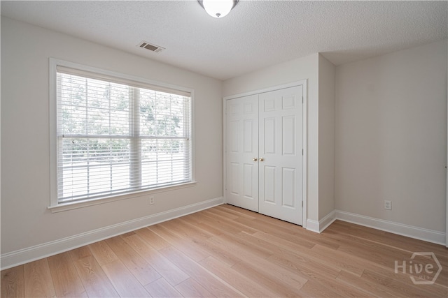 110 Pembroke Pl, Pembroke, GA 31321 - unfurnished bedroom featuring light wood-style flooring, a closet, baseboards, and a textured ceiling