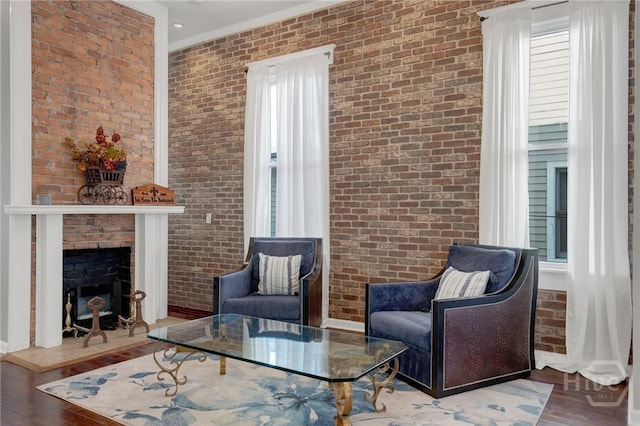835 E Duffy St, Savannah, GA 31401 - living area with brick wall, wood finished floors, crown molding, and a brick fireplace