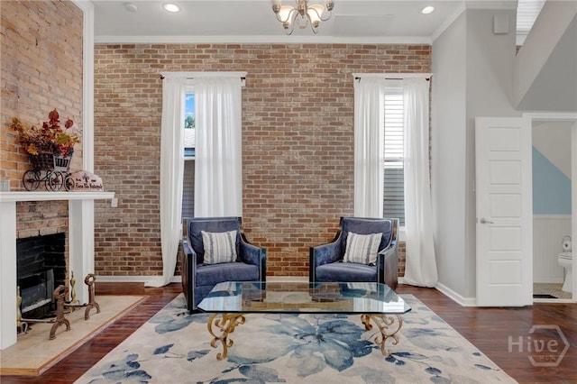 835 E Duffy St, Savannah, GA 31401 - living area featuring brick wall, wood finished floors, crown molding, a brick fireplace, and baseboards