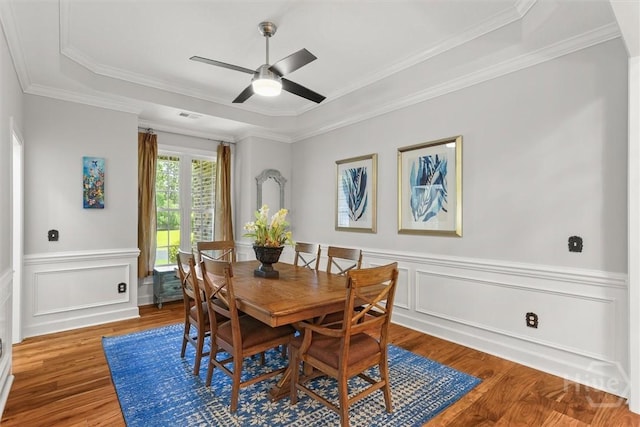 2 Misty Marsh Ct, Savannah, GA 31419 - dining area featuring a raised ceiling, wood finished floors, a ceiling fan, wainscoting, and crown molding