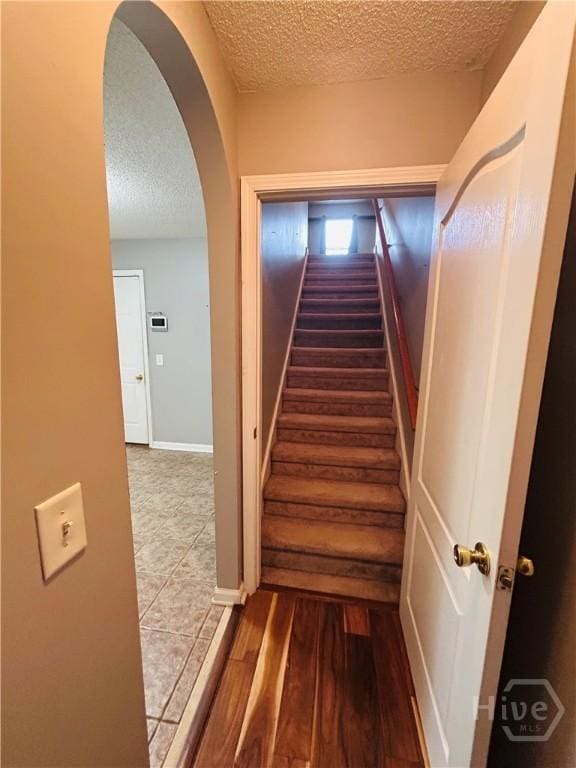 152 Junco Way, Savannah, GA 31419 - stairs with a textured ceiling, arched walkways, and wood finished floors