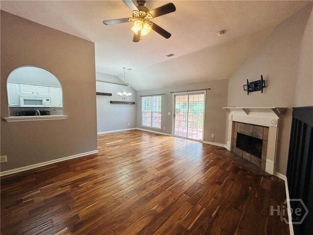 152 Junco Way, Savannah, GA 31419 - unfurnished living room featuring lofted ceiling, hardwood / wood-style flooring, a chandelier, a tiled fireplace, and ceiling fan
