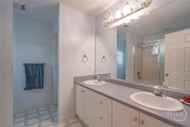 417 Willowpeg Way, Rincon, GA 31326 - full bathroom featuring tile patterned floors, double vanity, baseboards, a textured ceiling, and combined bath / shower with glass door
