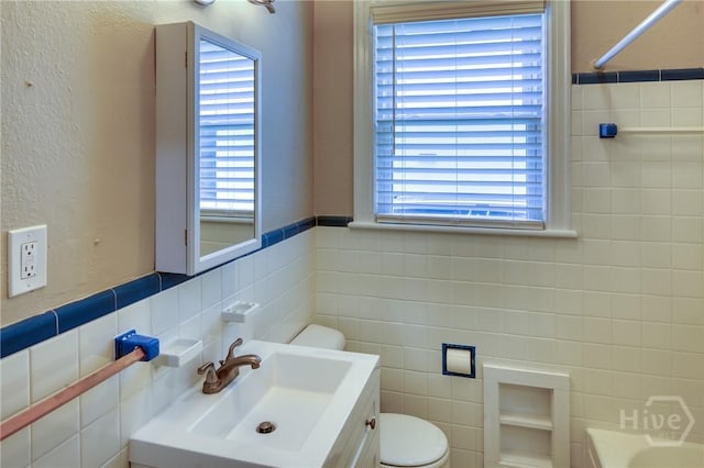 126 E 53rd St, Savannah, GA 31405 - full bathroom with tile walls, toilet, plenty of natural light, and vanity