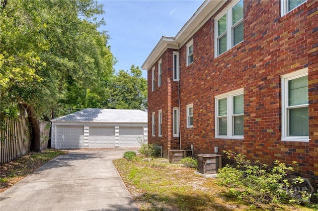 126 E 53rd St, Savannah, GA 31405 - view of property exterior with central AC, an outdoor structure, a detached garage, and brick siding