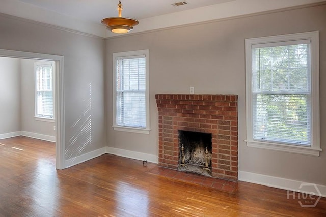 126 E 53rd St, Savannah, GA 31405 - unfurnished living room with wood finished floors, baseboards, a brick fireplace, and healthy amount of natural light