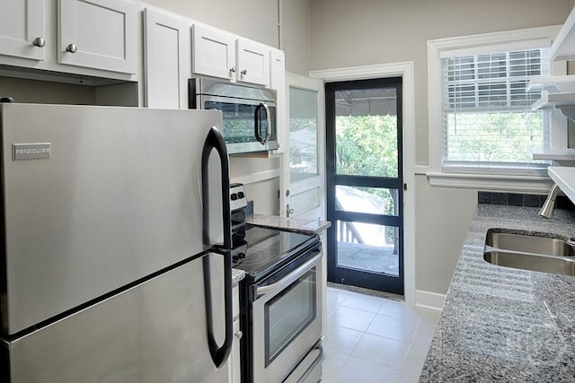 126 E 53rd St, Savannah, GA 31405 - kitchen featuring stainless steel appliances, a sink, light tile patterned floors, light stone counters, and white cabinetry