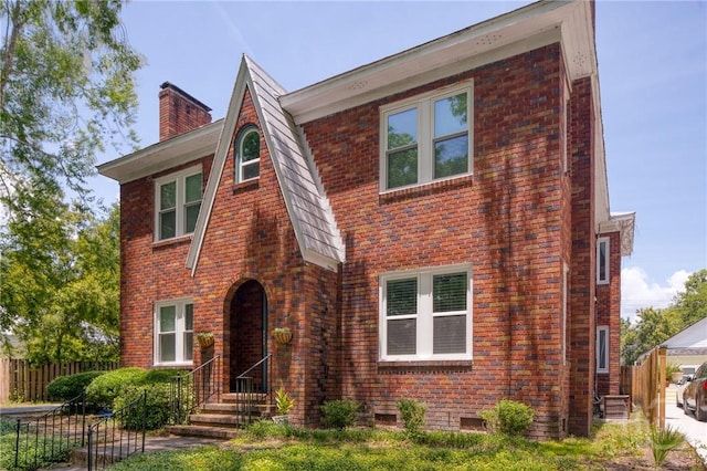 126 E 53rd St, Savannah, GA 31405 - english style home with a chimney, fence, and brick siding