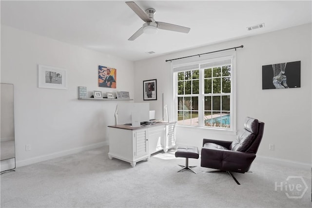 living area with carpet floors, a ceiling fan, baseboards, and a desk