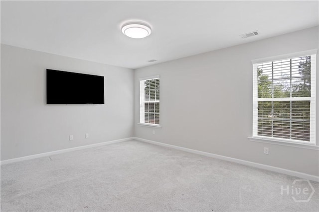 empty room with baseboards and light colored carpet