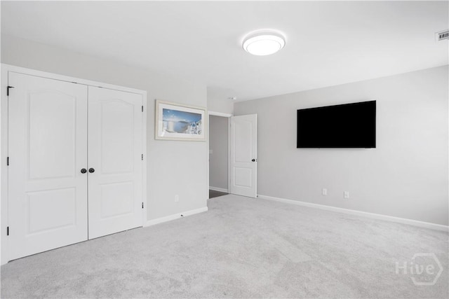 unfurnished bedroom with carpet floors, a closet, and baseboards