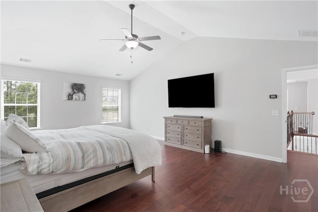 bedroom with vaulted ceiling, wood finished floors, multiple windows, and baseboards
