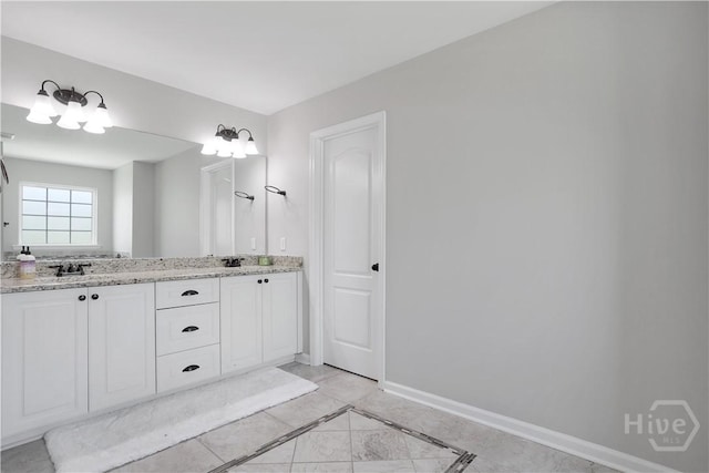 full bathroom with double vanity, baseboards, inlaid floor details, and tile patterned floors