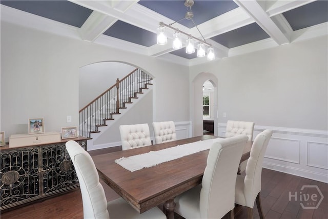dining room featuring coffered ceiling, arched walkways, stairway, dark wood-style floors, and beam ceiling